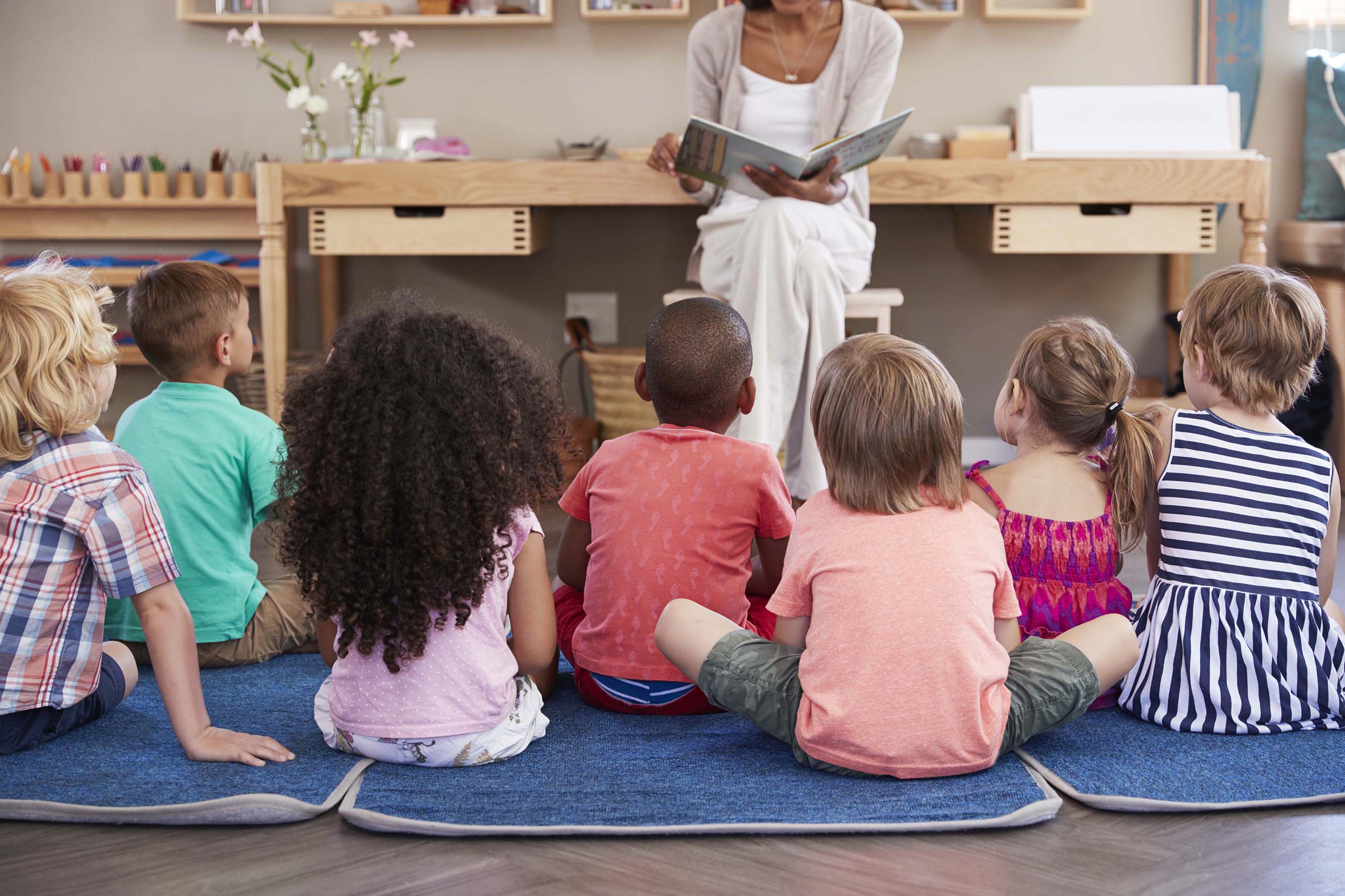 Teacher reading to a group of children in a classroom setting