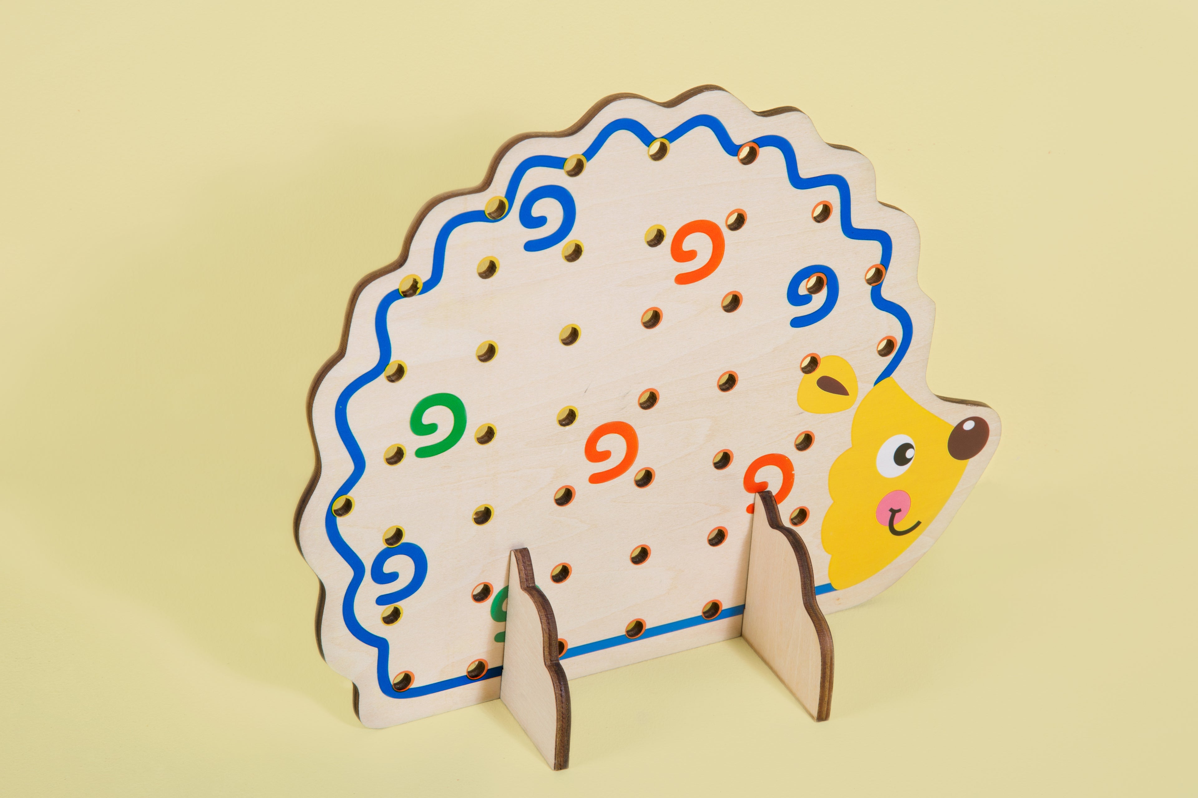 Educational toy peg board in shape of a hedgehog.
