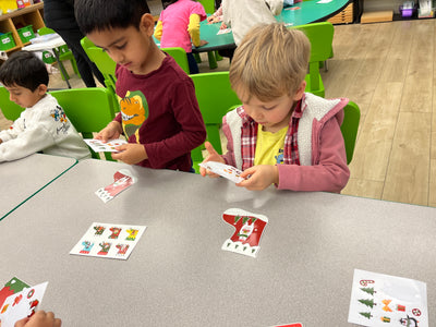 Children playing with cards at a table in a classroom setting