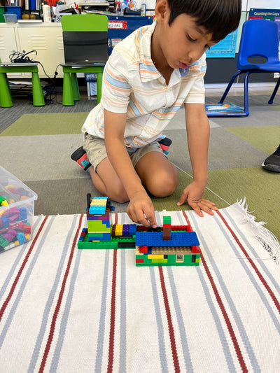 Child playing with building blocks on a striped rug